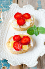Bruschetta with cheese , honey and strawberries