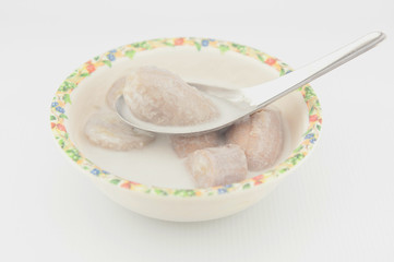 Banana in coconut milk on metal spoon show Thai dessert