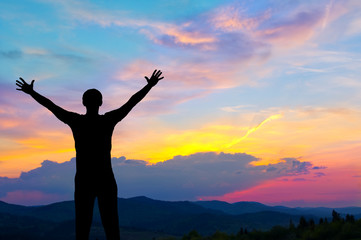Fototapeta premium Silhouette of man in the mountains at sunset