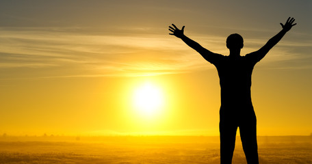 Fototapeta premium Silhouette of man on the field in the morning at sunrice