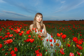 girl in a white dress in the poppy field