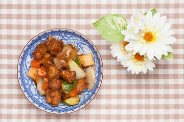sweet and sour pork and white artificial flowers