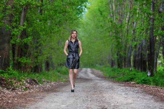 Beautiful elegant woman walking on a country road
