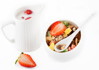 Granola (muesli) with strawberries, dried fruit and milk.