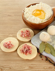 Raw dumplings, ingredients and dough, on wooden table