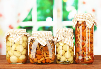 Delicious marinated mushrooms in glass jars,