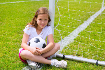 Soccer football kid girl relaxed on grass with ball