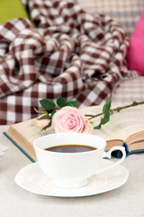 Composition with cup of drink, book and flowers