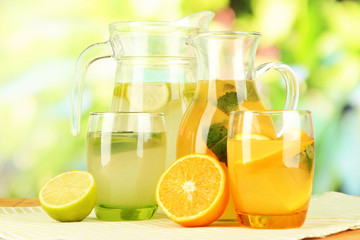 Orange and lemon lemonade in pitchers and glasses