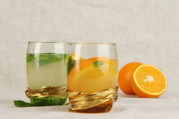 Lemonade in glasses on fabric background close-up