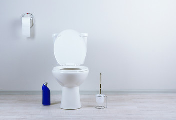 White toilet bowl and  cleaner bottle in a bathroom