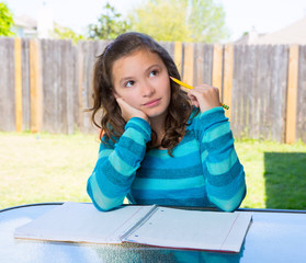 American latin teen girl doing homework on backyard