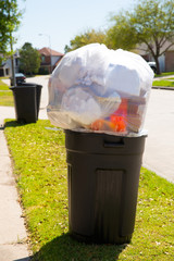 Trash bin dustbin full of garbage on street lawn
