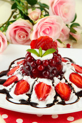 Tasty jelly dessert with fresh berries, on pink roses