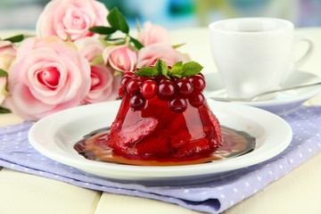 Tasty jelly dessert with fresh berries, on bright background