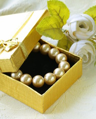 pearl necklace in a gold gift box