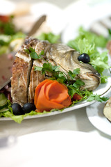 fish decorated with slices of cucumber,parsley and carrot