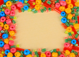 Fototapeta na wymiar Different colorful beads on beige background
