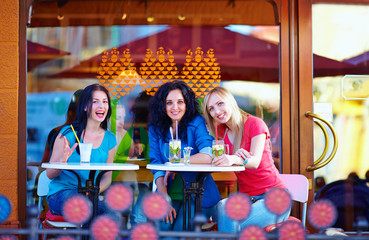 Obraz na płótnie Canvas happy friends sitting on summer cafe terrace