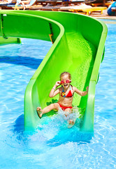 Child on water slide at aquapark.