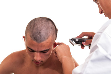 Fototapeta premium Barber cutting hair with clipper on white background