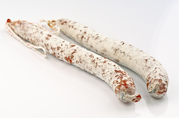 two sticks of fuet on white base