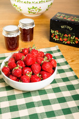 Bowl of strawberries and jars of jam