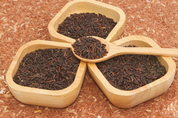 Thai black jasmine rice (Rice berry) in wooden bowl on brown ric