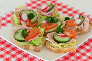 Sandwiches with ham and salad on checkered napkin