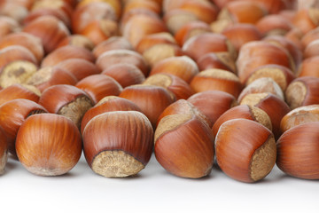 Unbroken hazelnuts on white surface