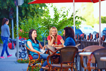 beautiful female friends sitting on cafe terrace