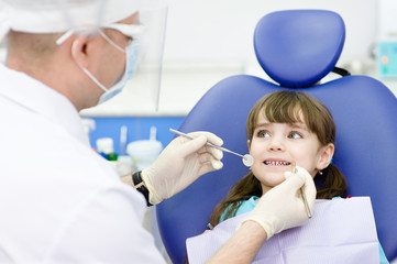 dental examining being given to little girl by dentist