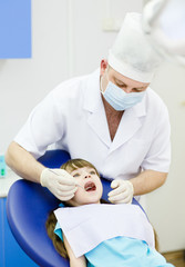 Obraz na płótnie Canvas small girl with open mouth while it being examined by dentist