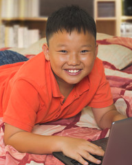 Asian boy working on a laptop computer