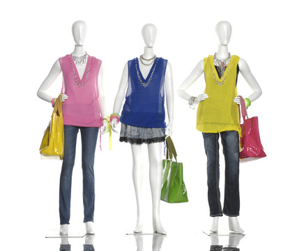 female clothing in jeans with scarf, bag on three mannequin