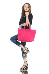 young woman in jeans with red bag posing