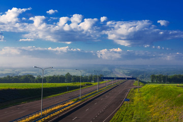 Fototapeta na wymiar highway among a green fields