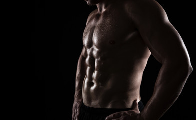Close up of perfect male body isolated on black background - obrazy, fototapety, plakaty