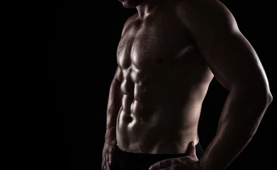 Fotobehang Close up of perfect male body isolated on black background © rangizzz