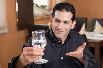 Mann prostet lächelnd mit Glas wasser