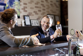 Two friends drinking beer in a bar