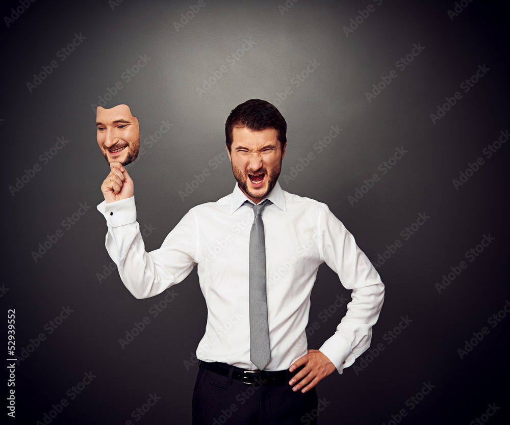 Wall mural man holding mask with smiley face