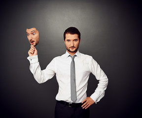 man holding mask with amazed face