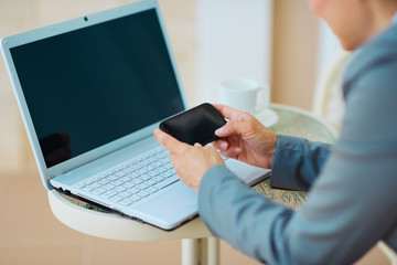 Closeup on business woman writing sms on terrace. rear view