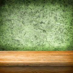 Background with wooden table and grunge green wall