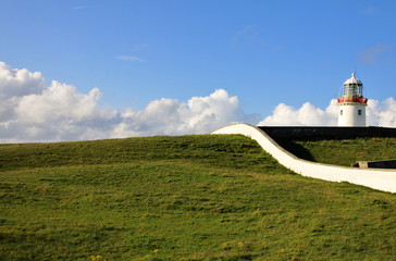 Irish Lighthouse on green meadow