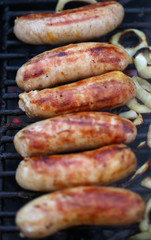 Sausages on grill with onions