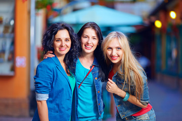 three beautiful girls friends on evening street