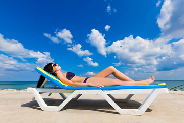 beautiful girl in a bikini lying on a deckchair