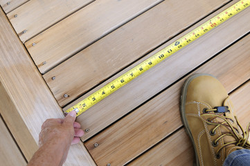 Worker Measuring Wood